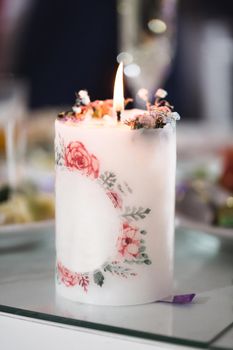 Wedding decor with crystals, lace, flowers and initials of the bride and groom. Wedding candles for the family hearth