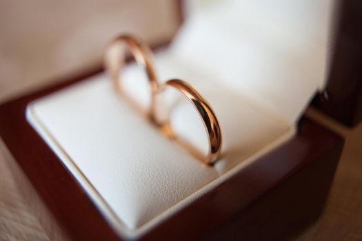 Elegant gold wedding rings in a wooden box.