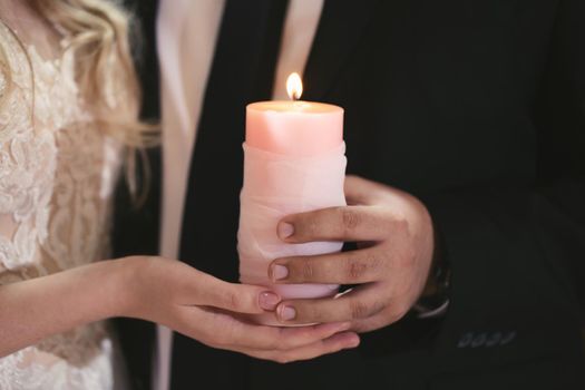 Wedding ceremony, paraphernalia, the bride and groom hold a large candle in their hand