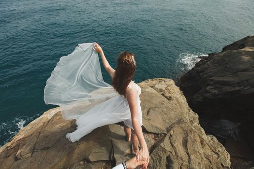 Beautiful young woman bride holds the hand of a man in outdoors. Follow me