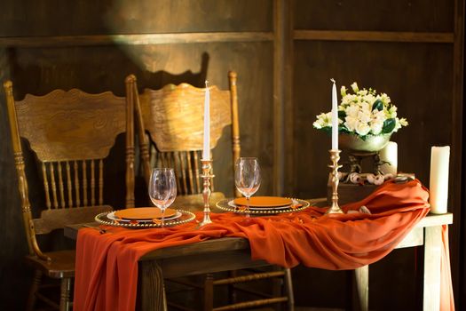 Table setting in the restaurant: flowers, candles and dishes.