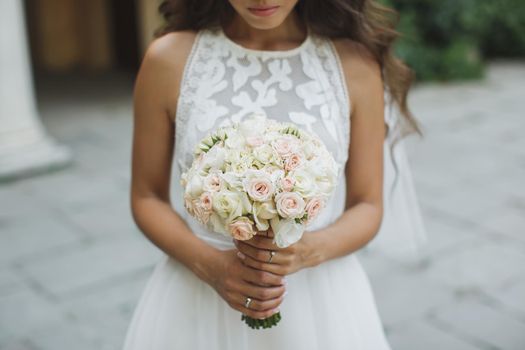 Beautiful wedding bouquet in hands of the bride