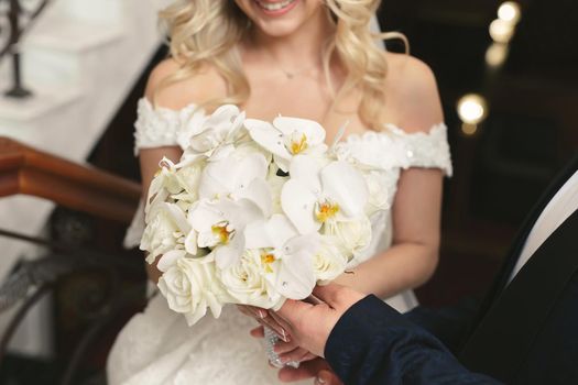 Luxury white wedding bouquet in the hands of the bride.