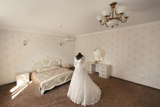 Chic wedding dress and veil on a mannequin in the bride 's gathering room