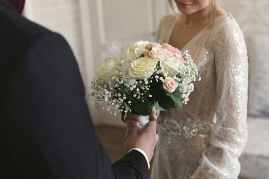 Groom gives the bride a bouquet of beautiful flowers.