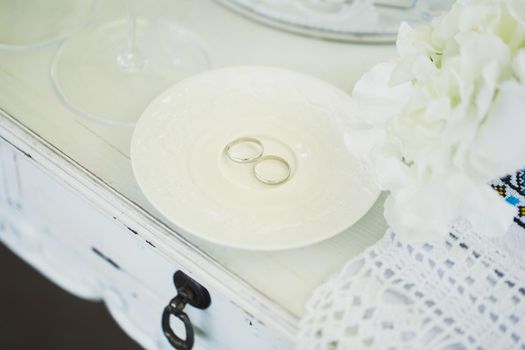 Wedding rings on a ceramic white saucer