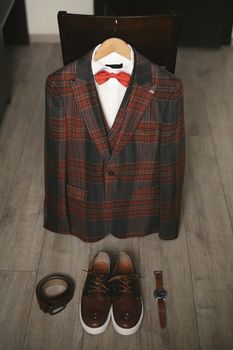 Stylish men's plaid suit and brown shoes, watch and groom's belt