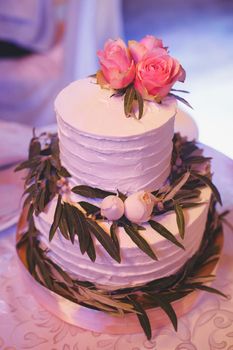 White delicate wedding cake with fresh flowers.