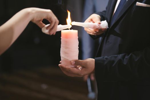 Wedding ceremony, paraphernalia, the bride and groom hold a large candle in their hand