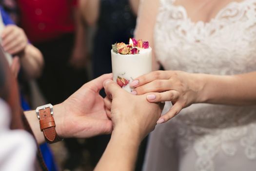 Wedding ceremony, paraphernalia, the bride and groom hold a large candle in their hand