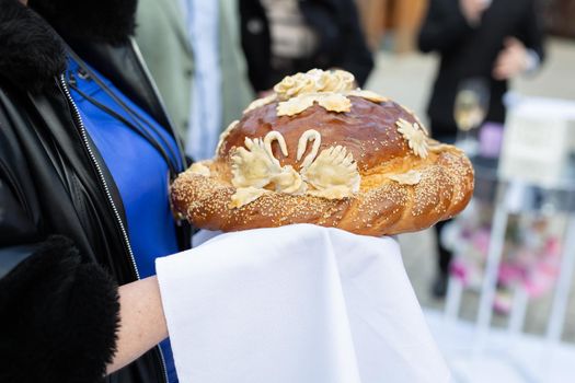 Wedding round loaf at the wedding in the hands of parents.