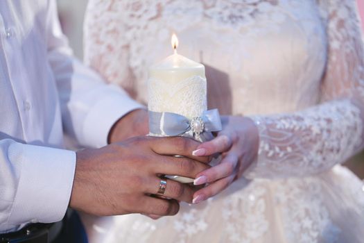 Wedding ceremony, paraphernalia, the bride and groom hold a large candle in their hand