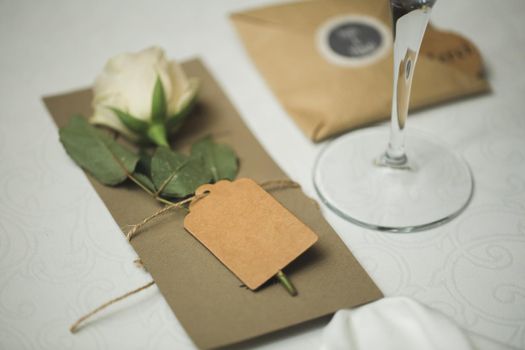 A nameplate on the wedding table with a live rose.
