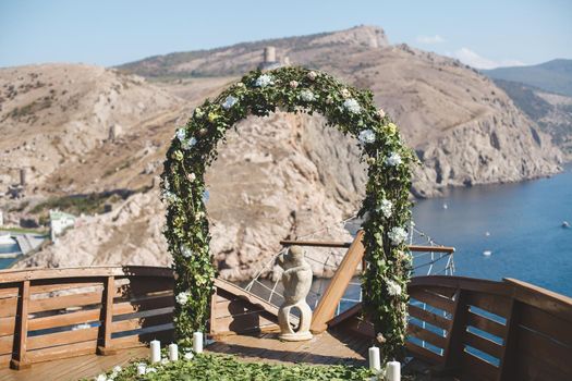 Luxurious wedding ceremony on a ship with a view of the sea and mountains.