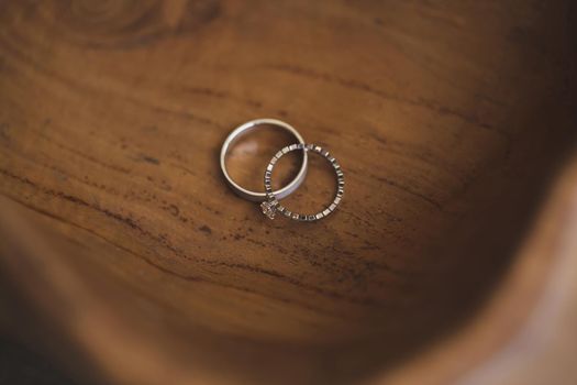 Wedding rings on a wooden texture close-up.