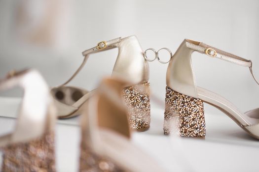 Gold wedding rings between the bride 's wedding shoes