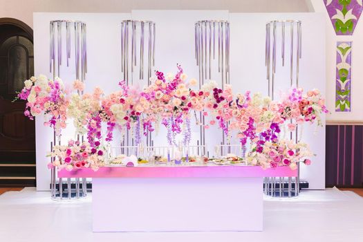 The table of the bride and groom in bright colors. Wedding decor at the banquet.
