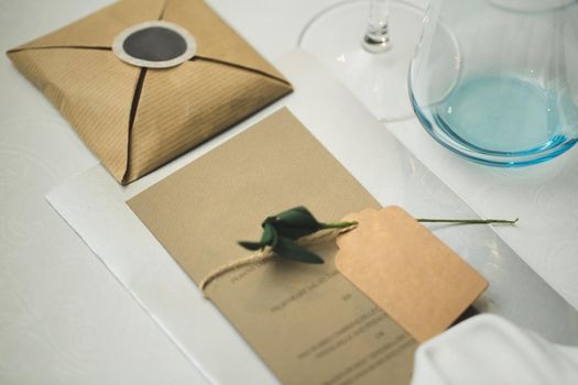 A nameplate on the wedding table with a live rose.