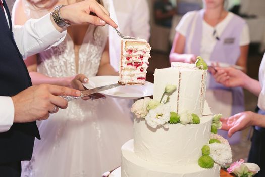 The bride and groom cut a gorgeous wedding cake at a banquet.