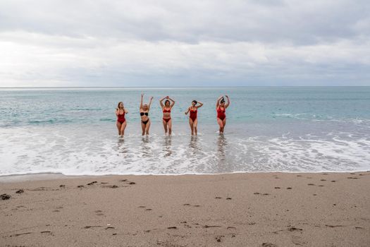 Big happy family or group of five friends is having fun against sunset beach. Beach holidays concept