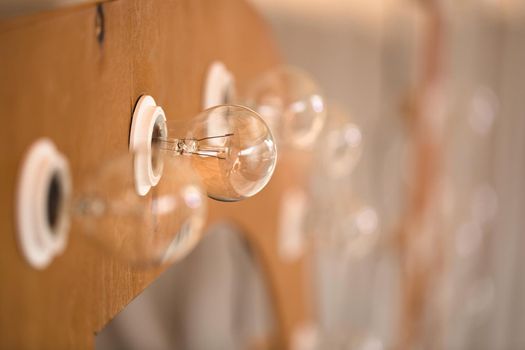 Wooden initials of the bride and groom with bright lights at the wedding.