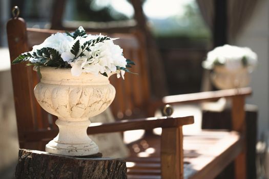 Flowers in a stone vase at a wedding ceremony.