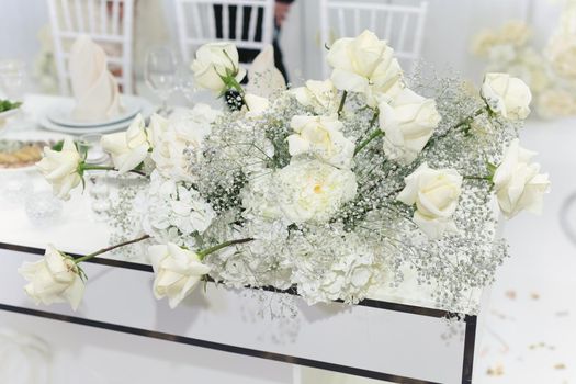 Wedding floral decor in white at a banquet in a restaurant.