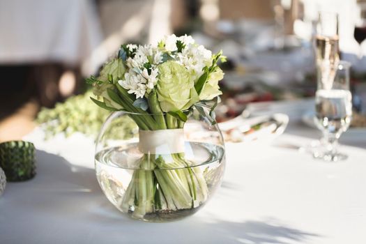 Table setting at a luxury wedding reception. Beautiful flowers on the table.