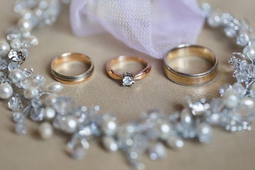 Gold wedding rings and necklace. Wedding accessories.