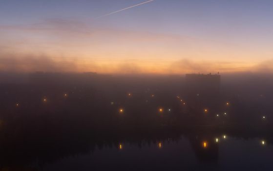 SEVERODVINSK, RUSSIA - MARCH, 11, 2021: Bright winter sunset against the background of houses. Multi-story houses in the rays of the sun. The sun goes down behind the houses