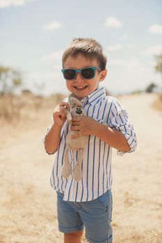 Happy boy holding a toy rabbit. Hare.