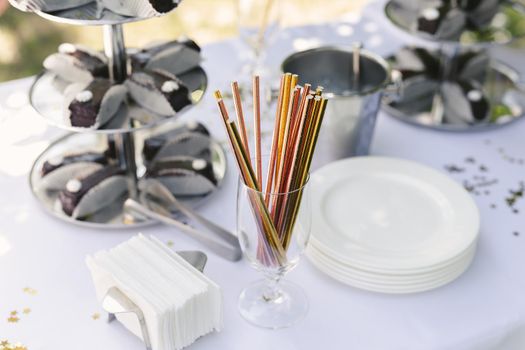 Colorful shiny straws for cocktails on the buffet table.