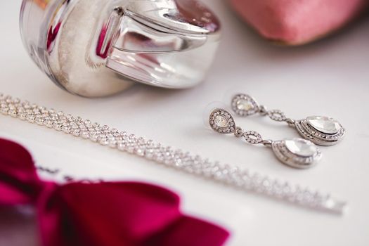 Bride's wedding accessories: perfume earrings bracelet bow.