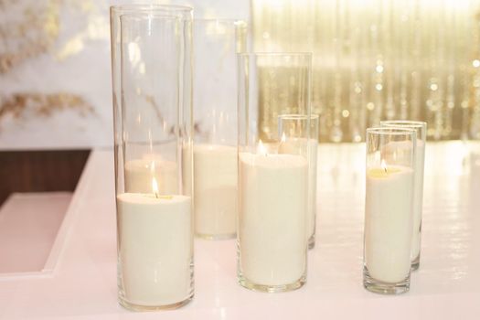 Wedding decor in white and gold style with candles and flowers.