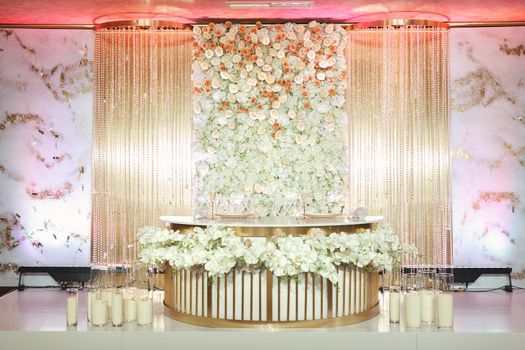 A luxurious table for the bride and groom at the wedding with flowers and candles.