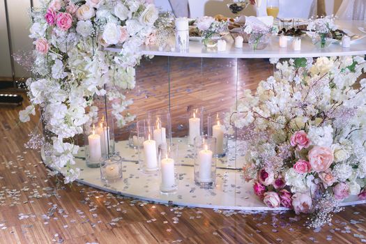 Wedding decor in a restaurant with candles and flowers.