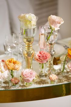 Table setting at a luxury wedding and Beautiful flowers on the table. wedding decor, flowers, pink and gold decor, candles.