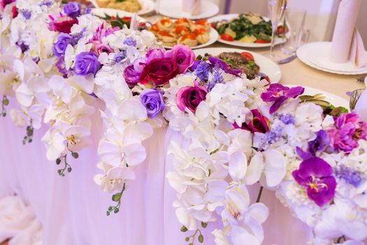 Colorful wedding bouquet of orchids on the restaurant table.