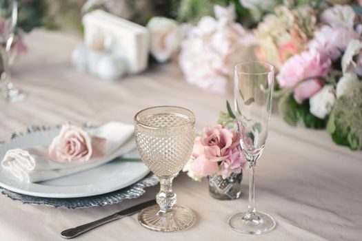 Delicate wedding table setting. A plate with a napkin and a rose.