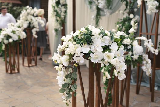 Details. Wedding ceremony in the open air of fresh flowers, with candles. Gentle and beautiful wedding decor for newlyweds.