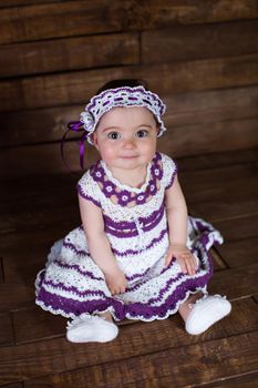 Beautiful girl in pink dress on a wooden background