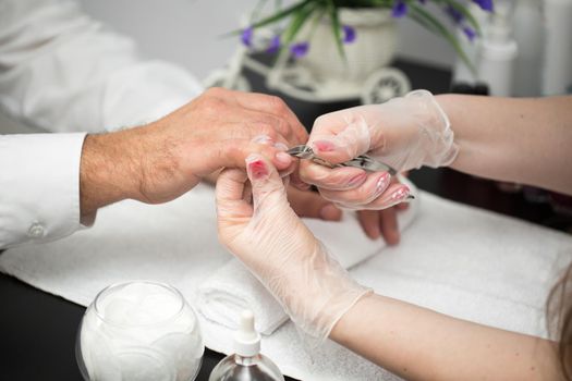 Close-up Of A Manicurist Cutting Off The Cuticle From The Person's Fingers