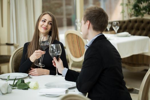 Romantic relationship concept - seducing beautiful woman looking at her lover with wine glass. Valentine's Day- concept