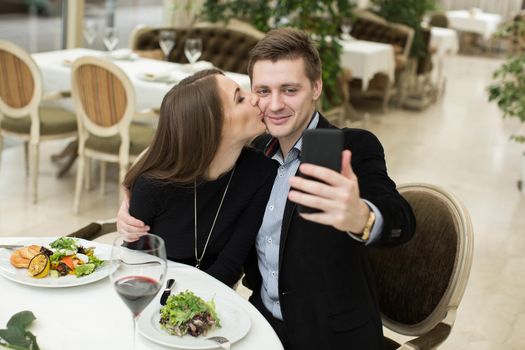 Beautiful couple taking selfie photo in a restaurant