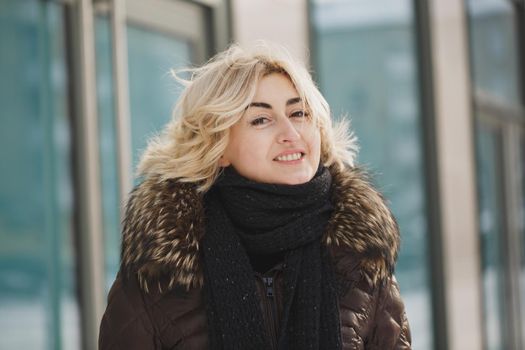 beautiful woman posing near the glass building