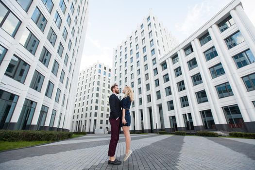 Man and woman hugging in the background is the building of the business center.