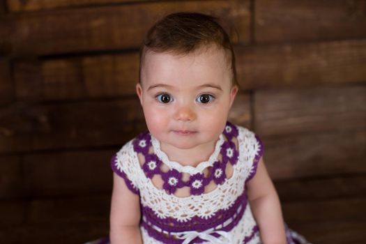 Beautiful girl in pink dress on a wooden background