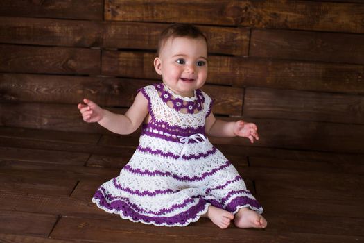 Beautiful girl in pink dress on a wooden background