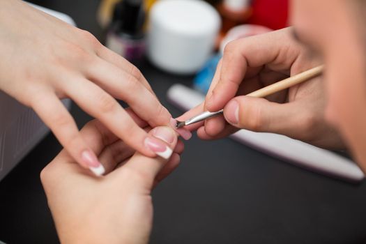 Closeup shot man making manicure to woman in beauty salon