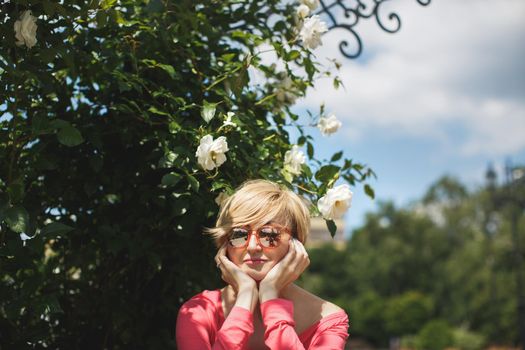 Beautiful girl in the Park. Blooming roses. Fountain.